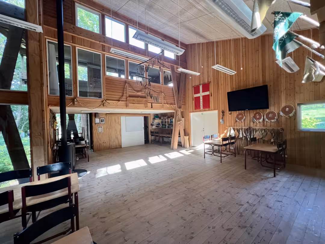Fællesrum i Bjørnholthytten med højt til loftet og naturligt lys