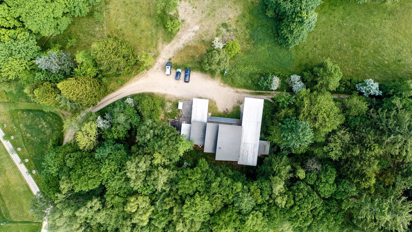 Bjørnholthytten set fra luften omgivet af skov