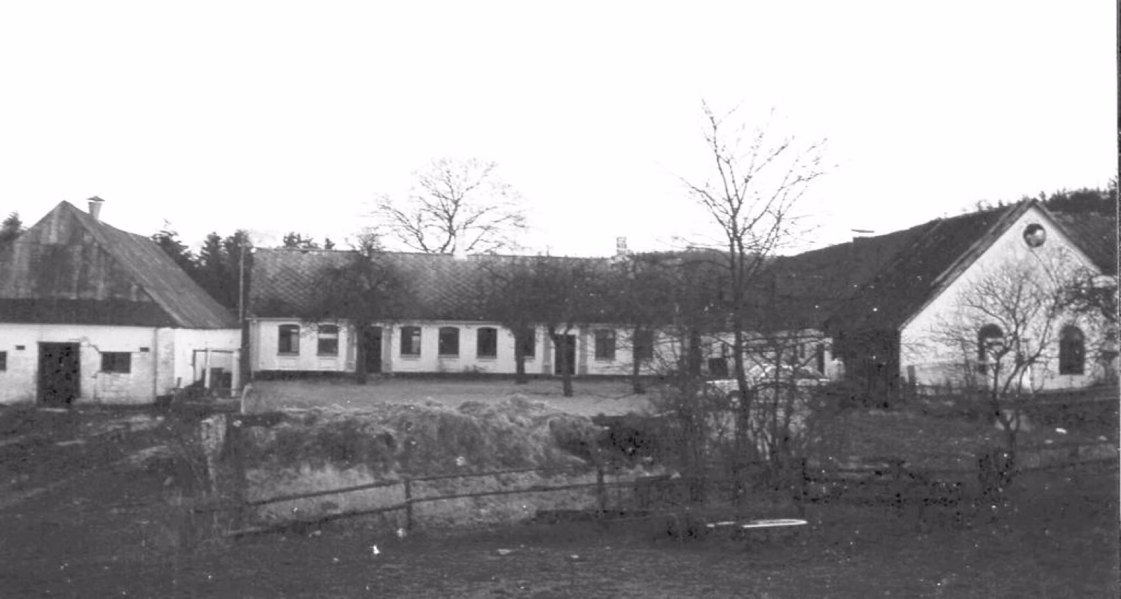 Bjørnholt-gården fotograferet omkring 1960 - sort-hvid billede af det lange stuehus og udlængerne